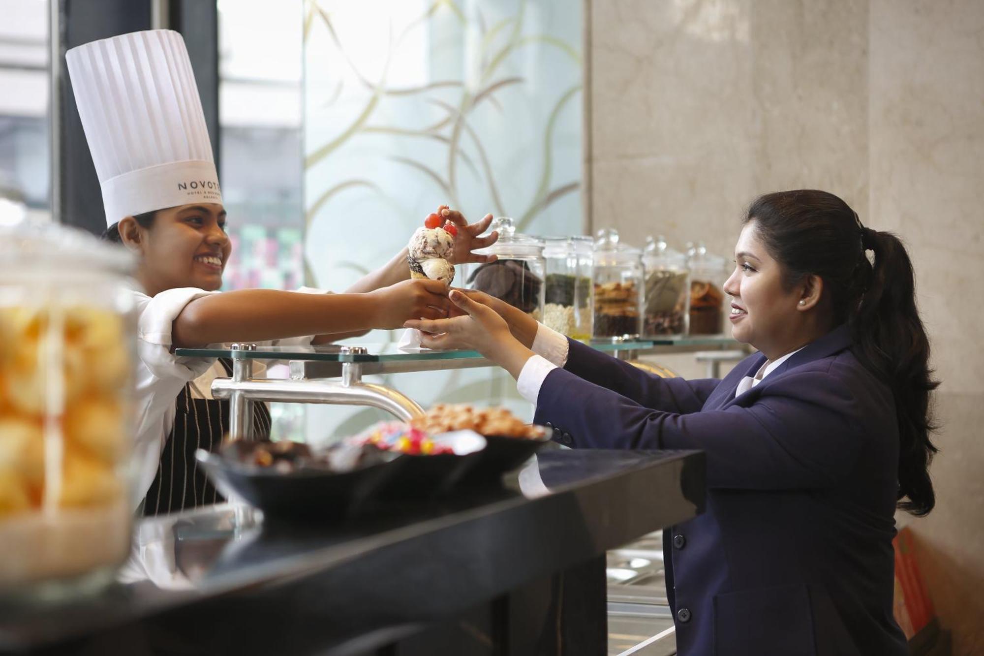 Novotel Kolkata Hotel And Residences Exterior foto A chef serving food to a guest
